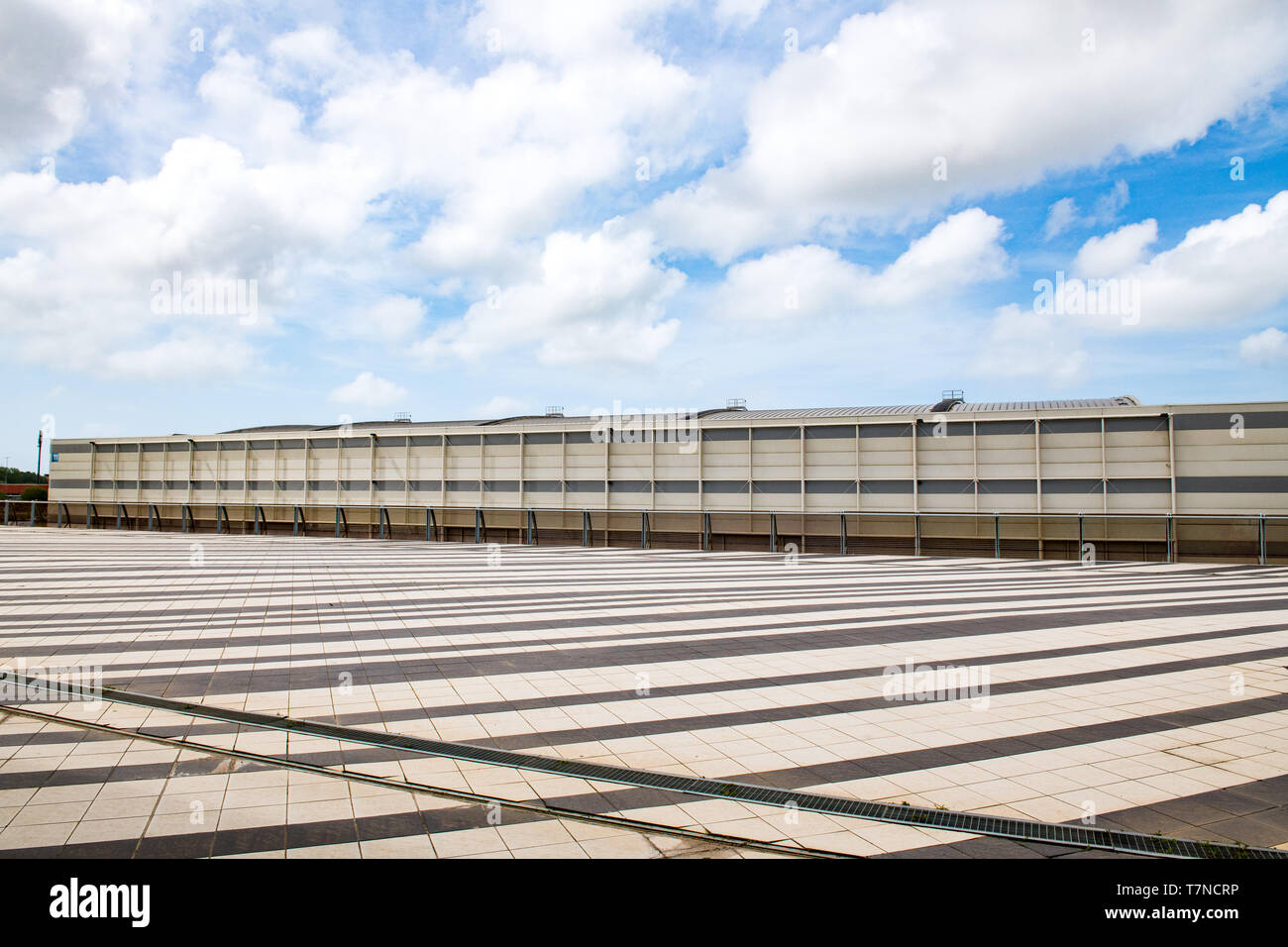 Weite Einstellung der modernen industriellen Gebäude Exterieur mit horizontalen Linien und blauer Himmel mit Wolken im Hintergrund Stockfoto