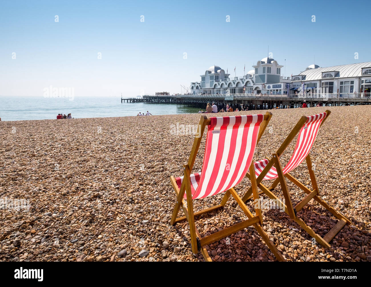 Liegestühle am Strand mit Southsea South Parade Pier im Hintergrund, Southsea, Portsmouth, Hampshire, Großbritannien Stockfoto
