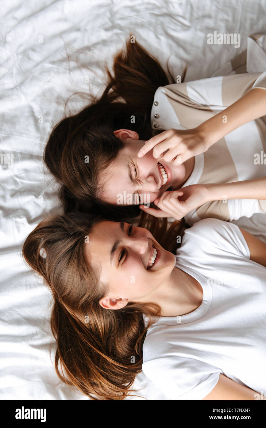 Teenage girls laughing on bed -Fotos und -Bildmaterial in hoher Auflösung –  Alamy