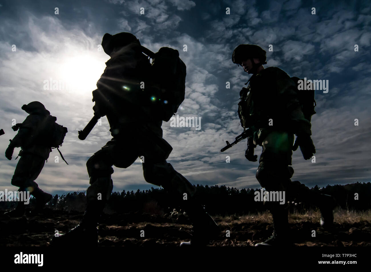 Gruppe der russischen Streitkräfte Luftlandetruppen (VDV-Vozdushno desantnye voyska) Soldaten in Ausübung Silhouette gegen Sonne, Himmel und Wolken marschieren Stockfoto