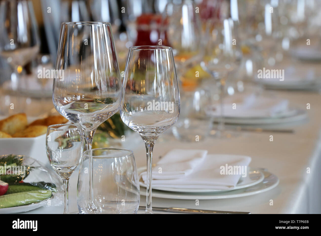 Bankett und Catering, Tisch im Restaurant für die Feier. Leere Gläser, Snacks und die Platten mit den Servietten auf dem Schreibtisch Stockfoto