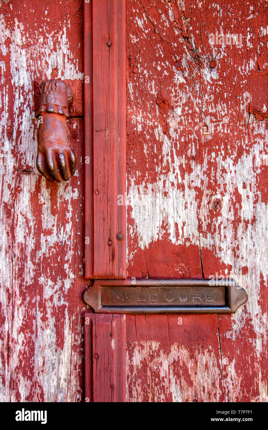 Klopfer und eine Mailbox im Namen 'Mr Le curé' auf einer hölzernen Tür mit abblätternde Farbe, Frankreich. Stockfoto