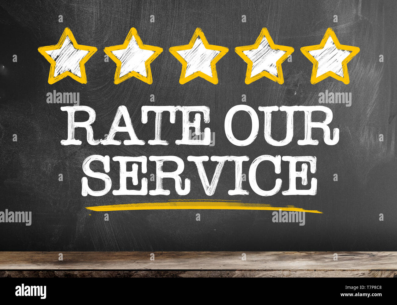 Text BEWERTEN SIE UNSER SERVICE auf Tafel mit fünf goldene Sterne und Hand Stück Kreide geschrieben Stockfoto