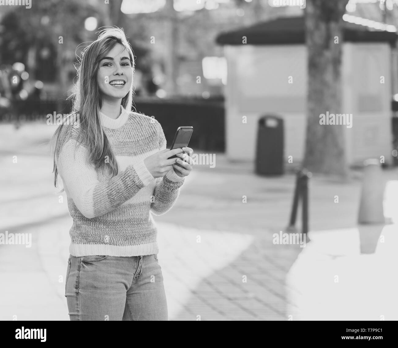 Recht glücklich student Frau online plaudern auf Smart mit Social Media Phone Apps außerhalb der Stadt. Schönen Teenager tragen stilvolle Kleidung fühlen Stockfoto