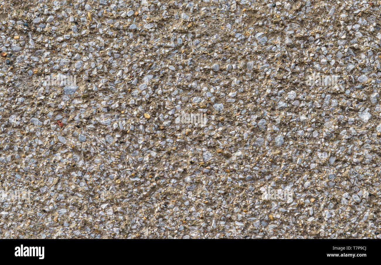 Betonwand mit Kies rauen Oberfläche, als Hintergrund Stockfoto