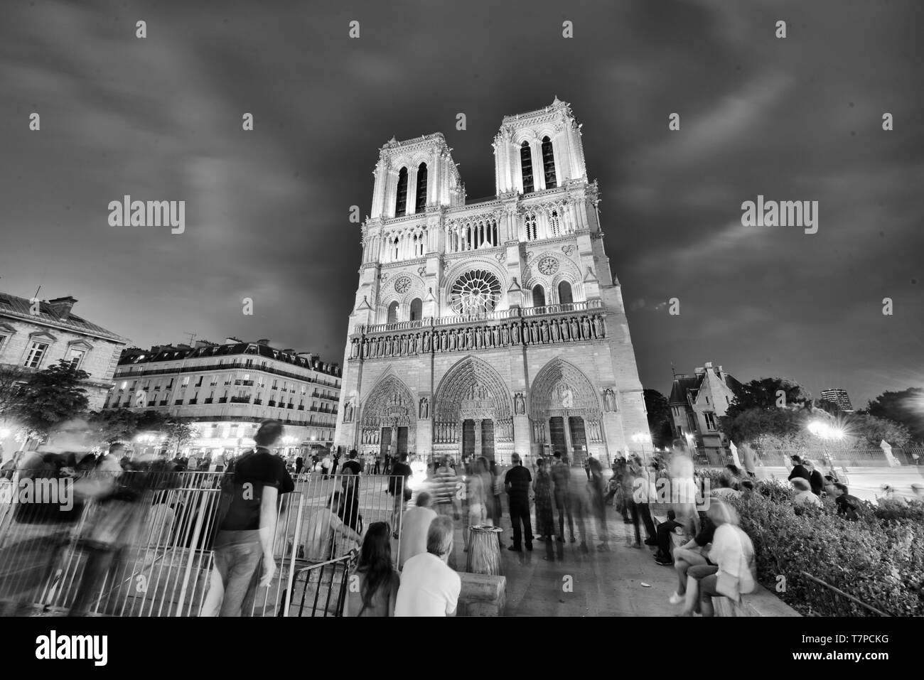 PARIS - JUNI 2014: Notre Dame Kathedrale bei Nacht mit Touristen. Notre Dame wird von 12 Millionen Menschen jährlich besucht. Stockfoto