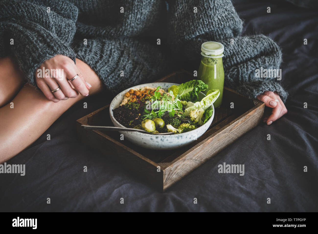 Gesund vegan Schüssel auf Fach und Frau in Pullover Stockfoto