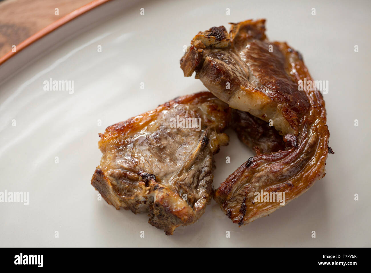 Zwei gekocht Britischen Lammkoteletts gekauft von einem Supermarkt, die in Olivenöl gebraten wurden. England UK GB Stockfoto