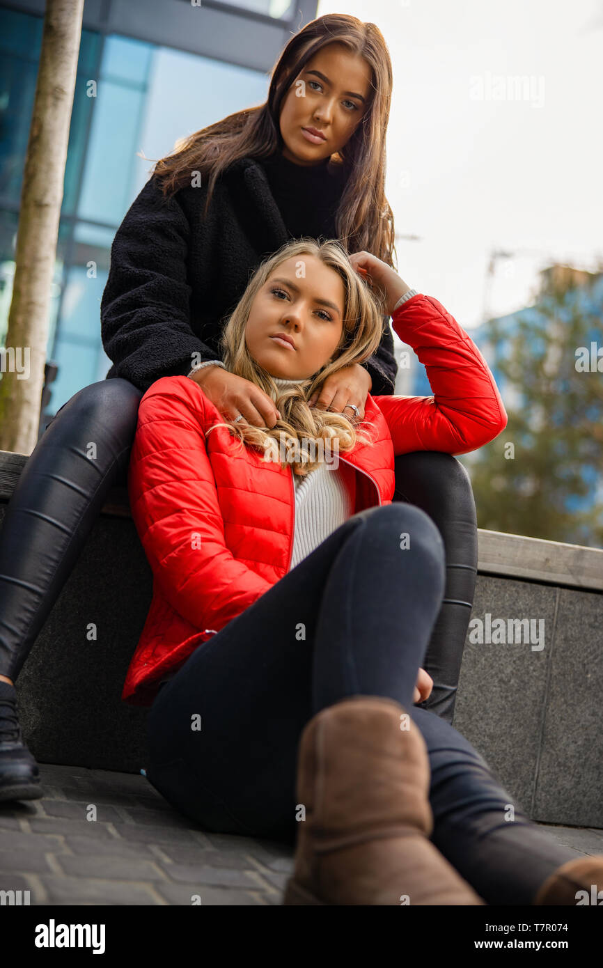 Portrait von modischen Freunde sitzen zusammen In der Stadt Stockfoto