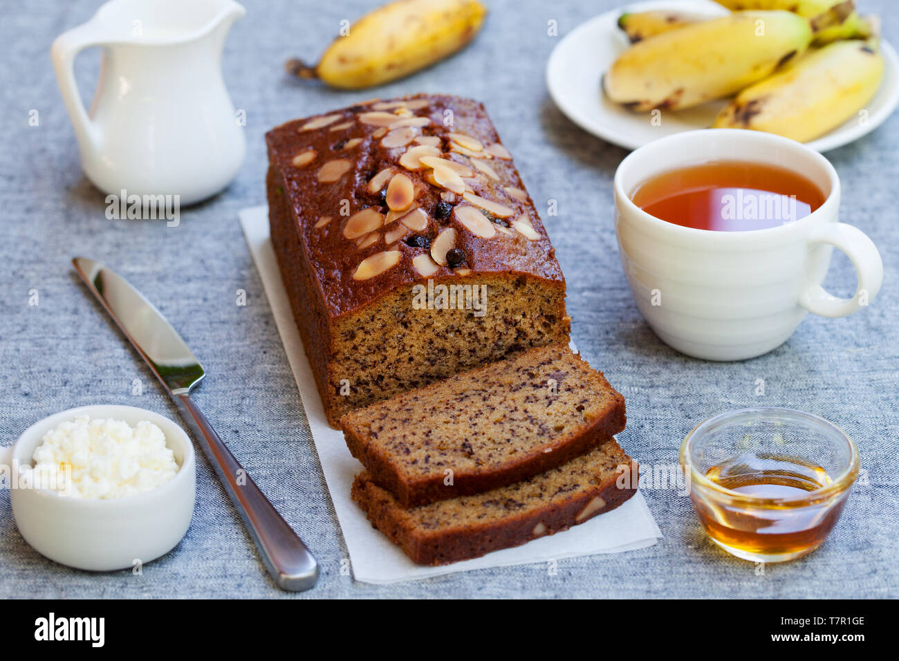 Banane Kuchen, Brot Brot mit Schokolade und Tee auf grau Background. Stockfoto