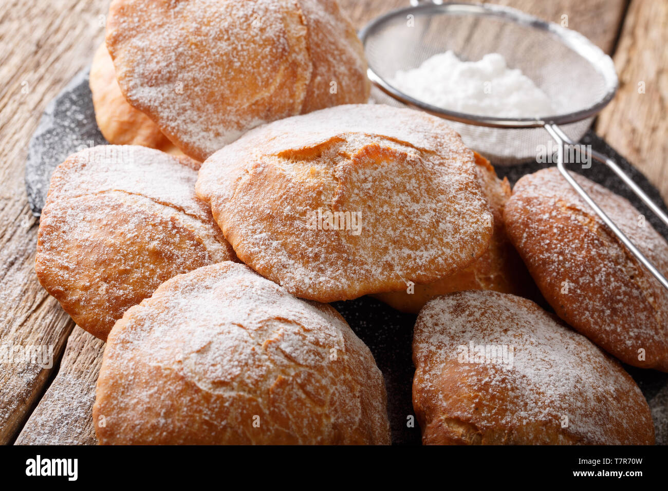 Süsse frittierte Bunuelos mit Puderzucker bestreut schließen - auf den Tisch. Horizontale Stockfoto