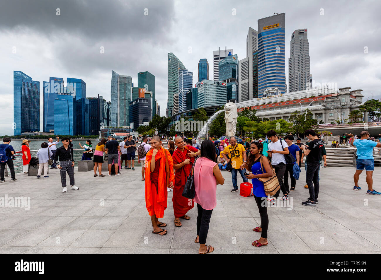 Touristen posieren für Fotos Vor dem Merlion Statue und die Skyline von Singapur, Singapur, Südostasien Stockfoto