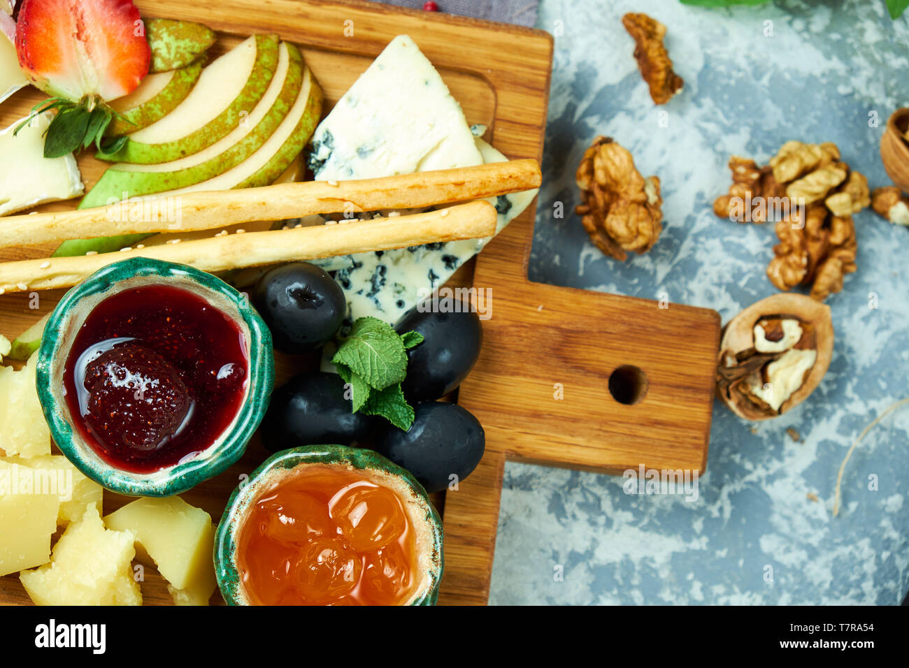 Käseplatte mit Soßen auf einem Holzbrett. Schöne Gerichte. Restaurant Menü Stockfoto