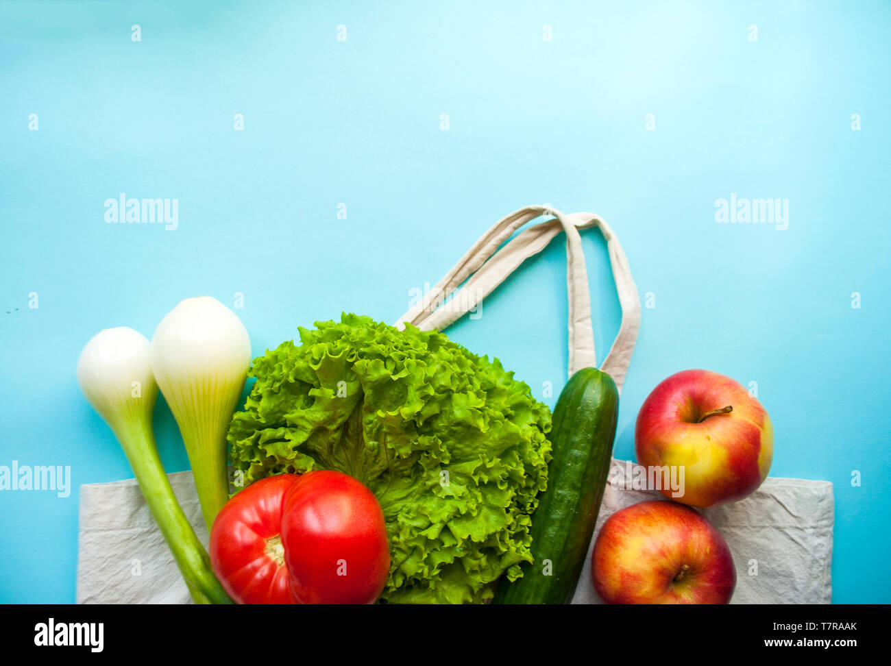 Frisches Obst und Gemüse im eco Beutel auf die türkise Farbe Hintergrund mit Copyspace. Kunststoff Konzept. Stockfoto