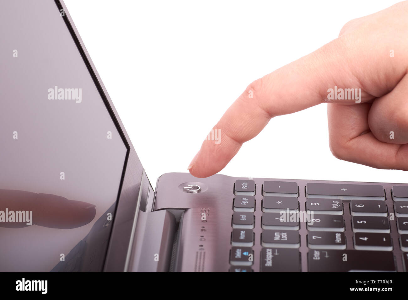 Nahaufnahme der weiblichen Hand mit Zeigefinger, und drücken Sie die Schaltfläche Start silber Laptop mit schwarzer Tastatur und Display. Schaltet das Notebook ein- oder ausgeschaltet. Ich Stockfoto