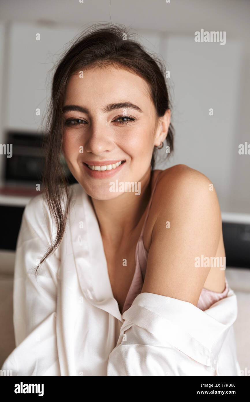 Porträt der europäischen Frau 20 s in Freizeitkleidung sitzen auf der Couch in der gemütlichen Wohnung Stockfoto