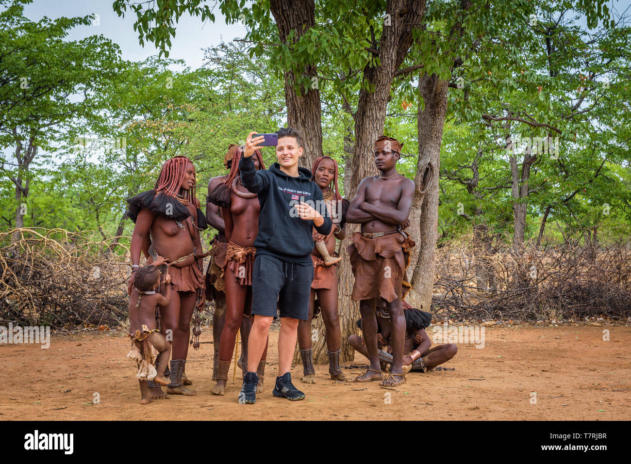 Tourist, der eine selfie mit einer Gruppe von Menschen Himba in Namibia Stockfoto