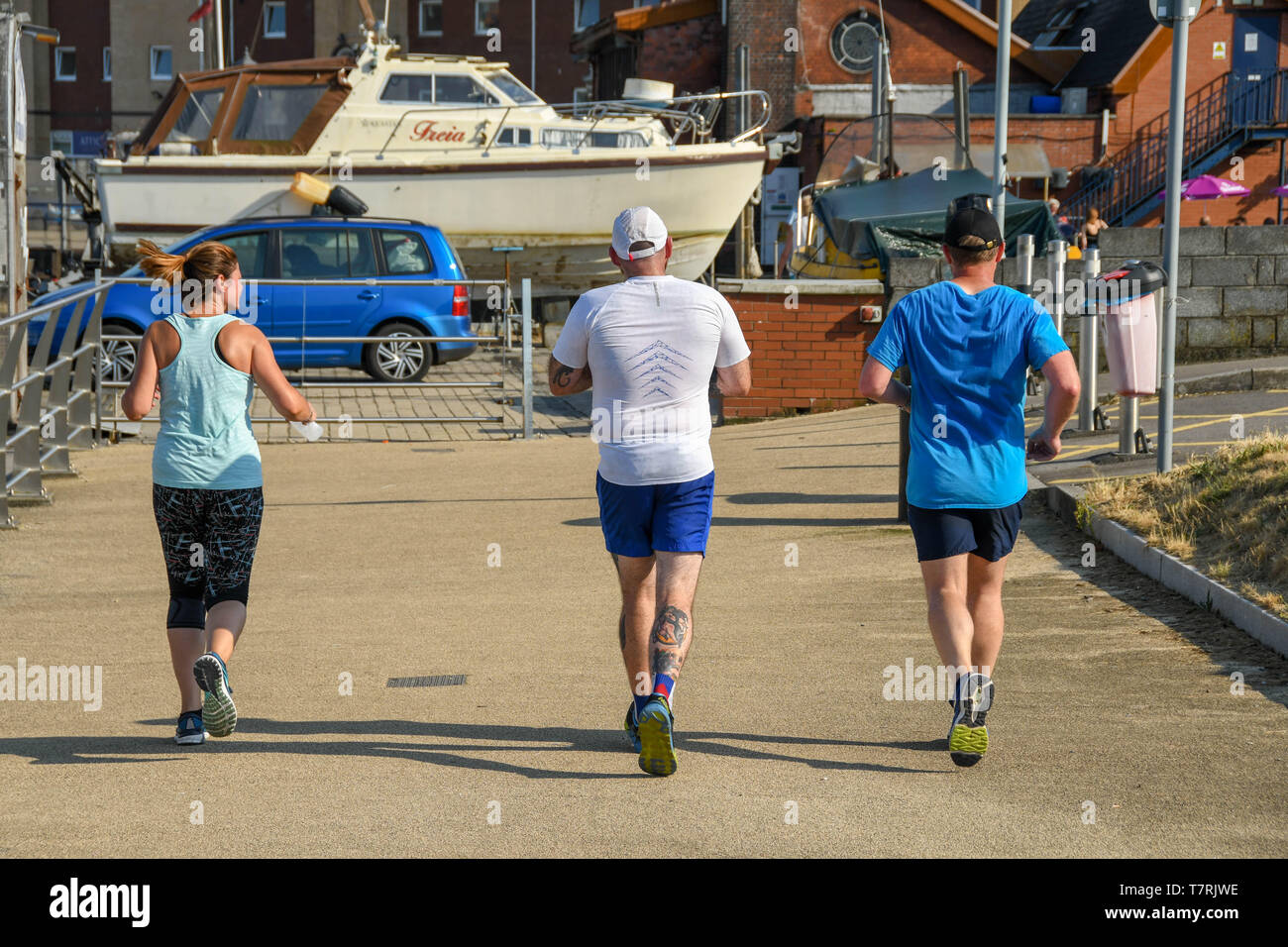 SWANSEA, WALES - Juli 2018: Drei Leute joggen in der Nähe von Swansea Marina Stockfoto