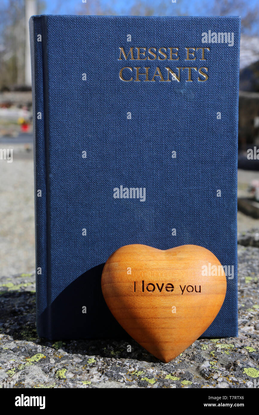 Coeur de bois d'Olivier et Livre de Messe et Chants dans un cimetire. Stockfoto