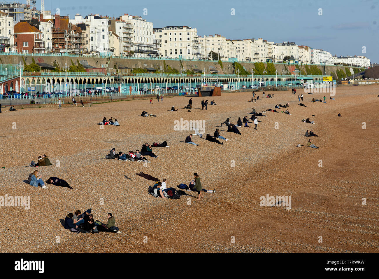 Man saß in der Sonne am Strand von Brighton Stockfoto