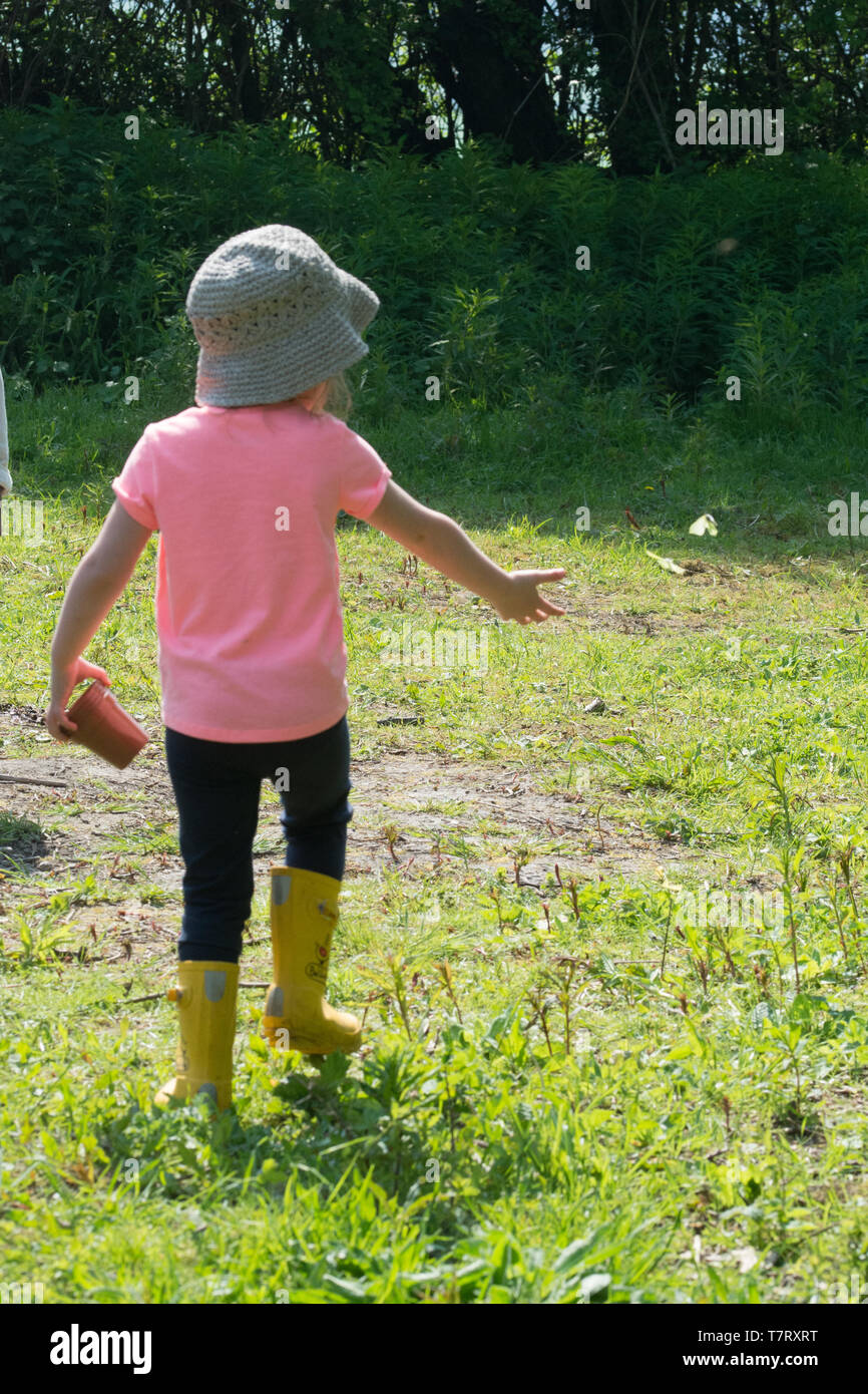 Vier Jahre altes Mädchen auf dem Land genießen Sie einen Schmetterling. Kinder und Natur Konzept. Stockfoto