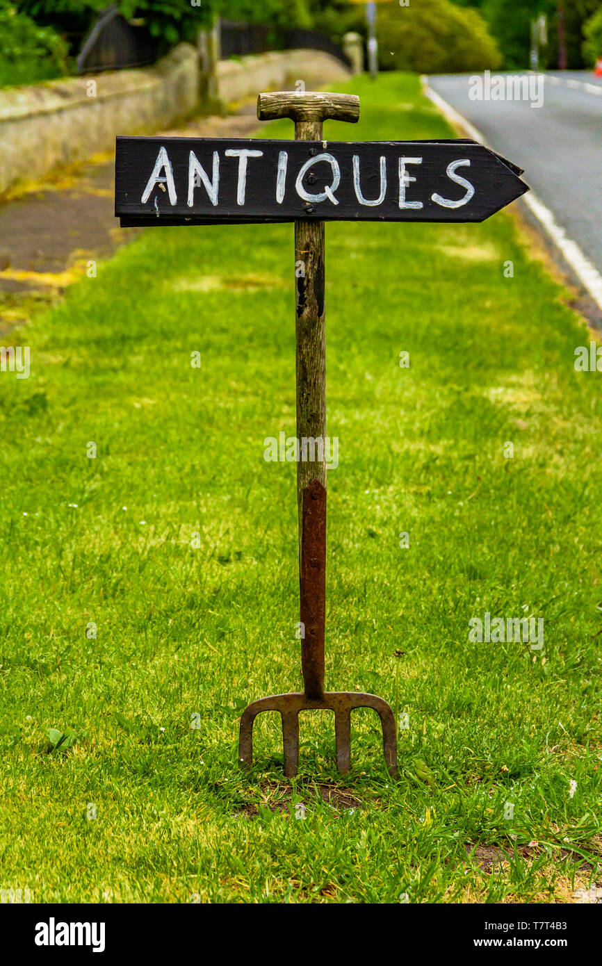 Handmade Zeichen aus einem alten Garten Gabel Werbung eine Antiquitäten Shop Ford in Dorf, Northumberland, Großbritannien. Mai 2018. Stockfoto