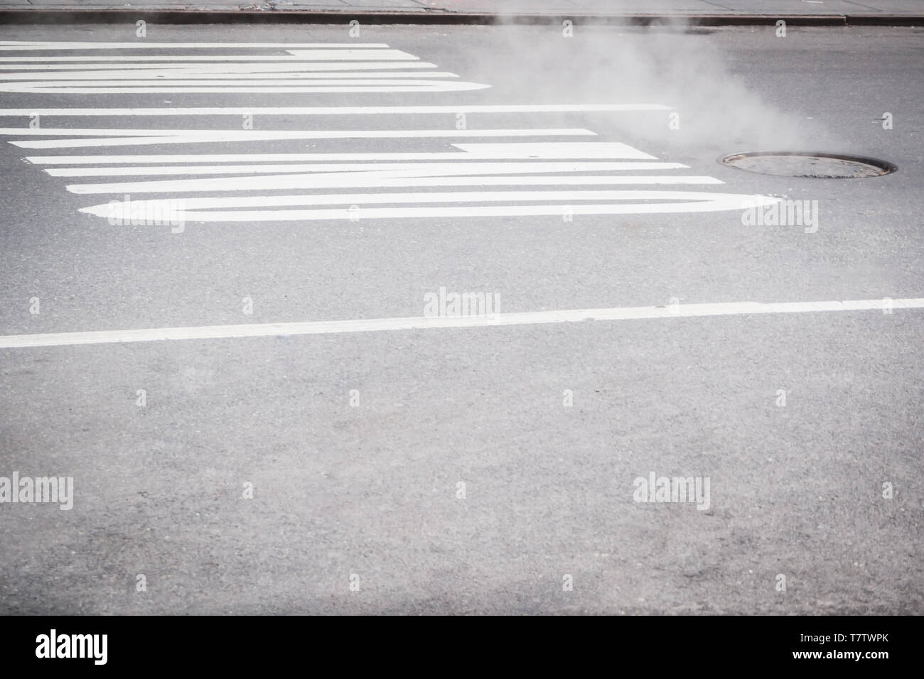Dampfende Kanaldeckel Sinnbild für die Straßen von Manhattan in New York Stockfoto