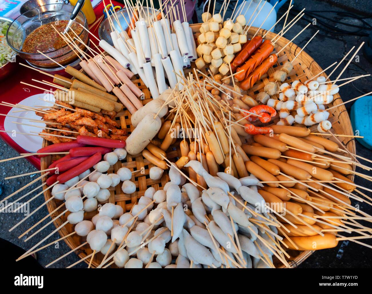 Verschiedene Spieße mit Wurst und Fleisch, Frikadellen, in Bambus Korb auf einem Markt, thailändische Küche, Thailand Stockfoto