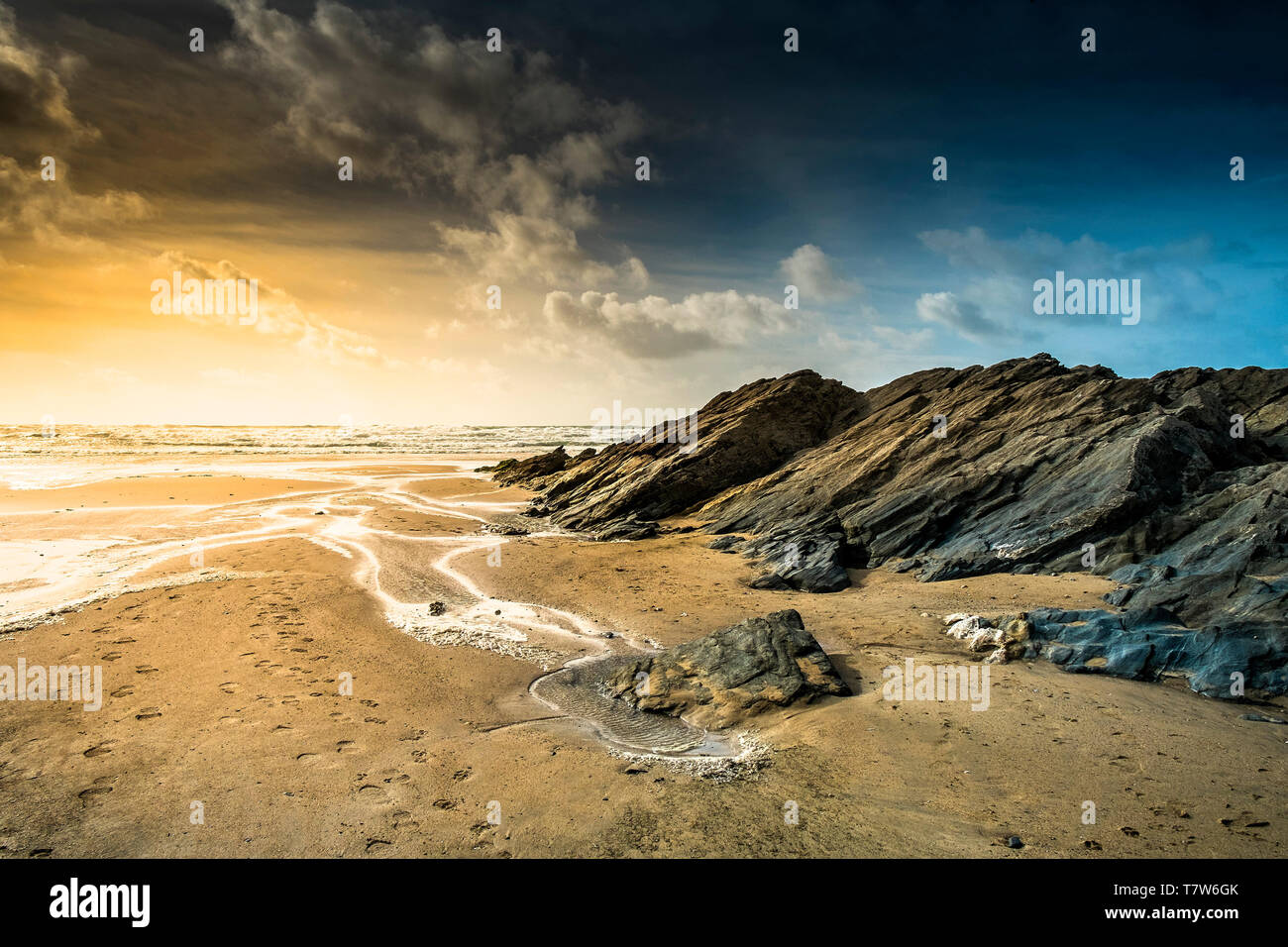 Abendlicht über Felsen bei Ebbe freiliegenden an der Küste bei Fistral in Newquay in Cornwall. Stockfoto