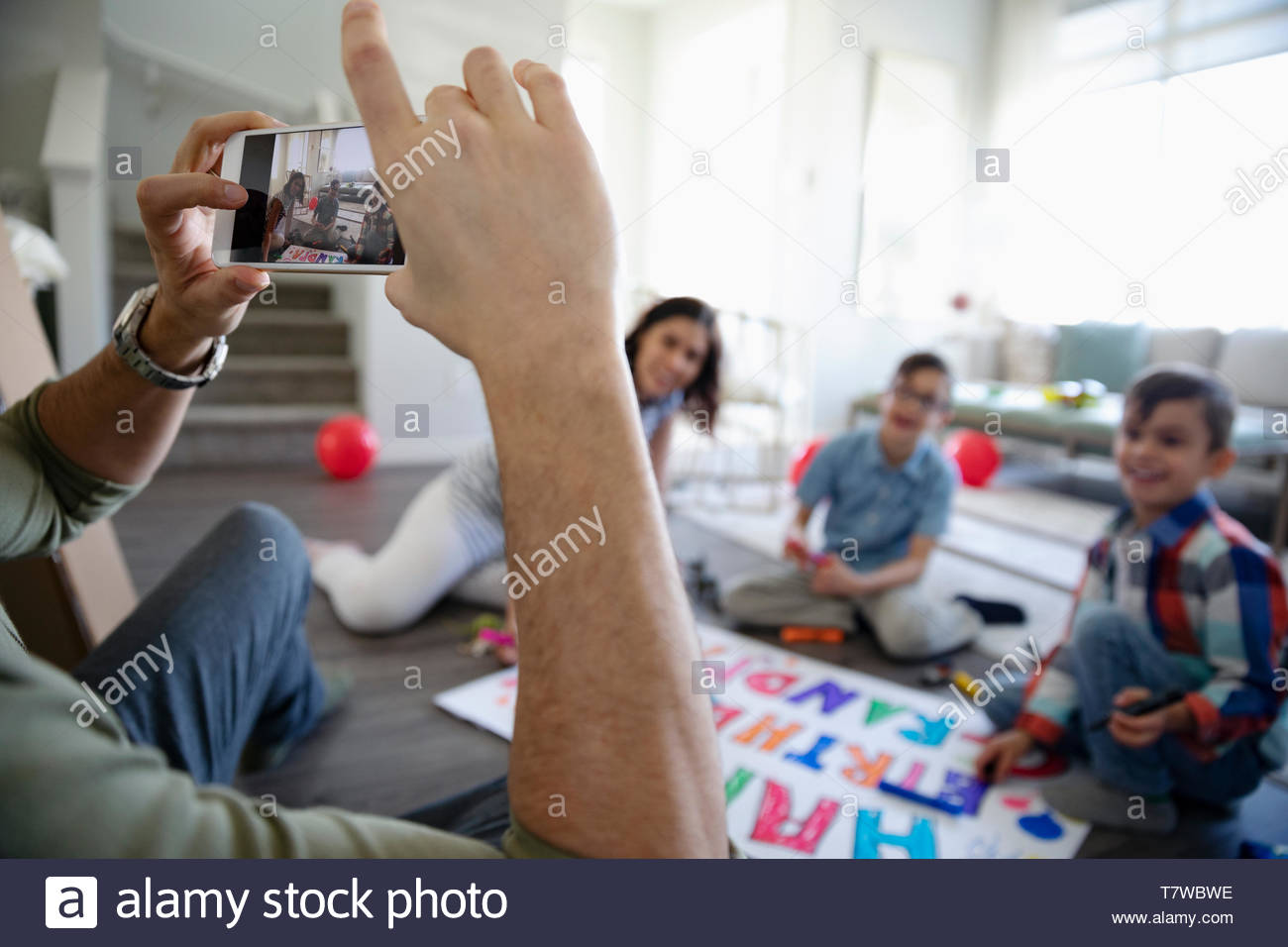 Vater fotografieren Familie Färbung Geburtstag singen im Wohnzimmer Stockfoto