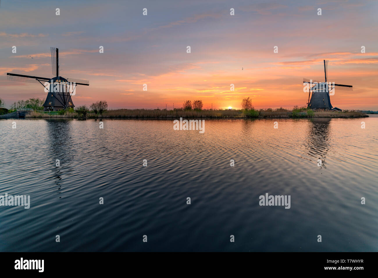 Lange Exposition der Kinderdjik Mühle sunrise Reflexion auf dem ruhigen Wasser des Alblasserdam canal Stockfoto