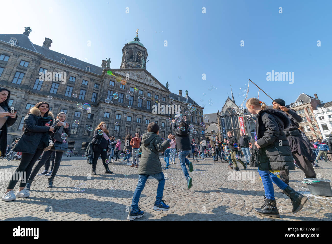 AMSTERDAM, 14. April 2019 - Wasser ballon Gebläse spielen mit Kinder und Kinder auf dem Dam Platz in Amsterdam unter einem sonnigen hellen Himmel Stockfoto