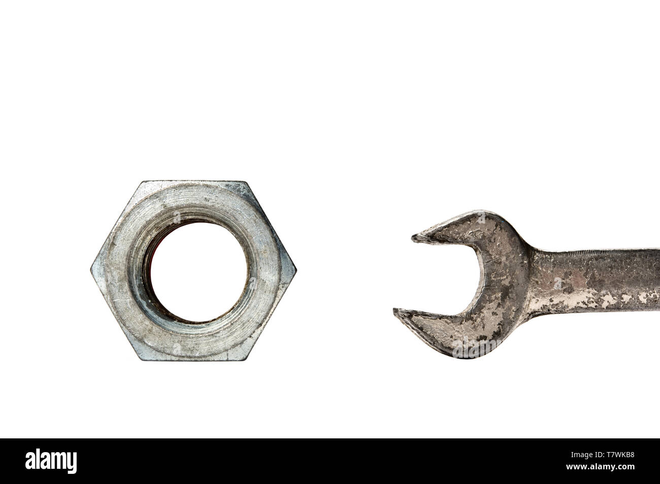 Große Sechskantmutter und Schraubenschlüssel auf weißem Hintergrund. Stockfoto
