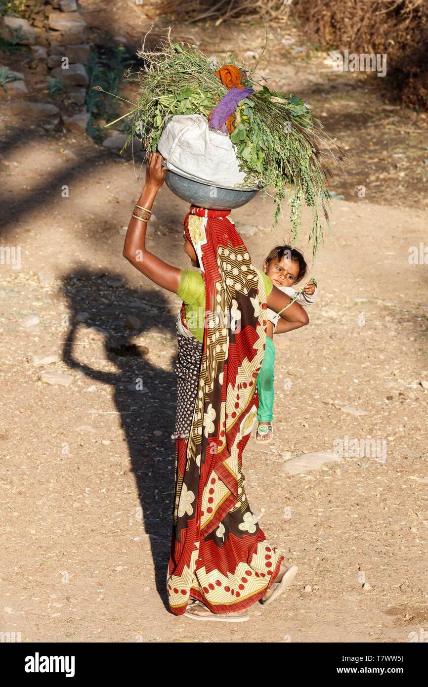 Indien, Madhya Pradesh, Chanderi, eine Frau, die ihr Baby tragen und Viehfutter Stockfoto