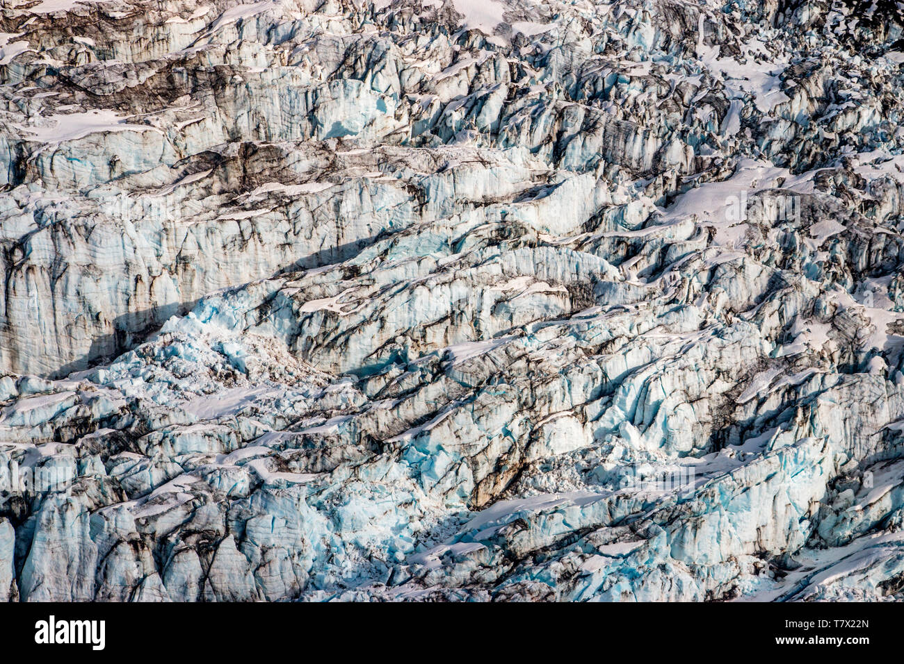 Die knik Gletscher in Alaska. Mangel an Schnee - Abdeckung setzen den Ascheregen vom nahe gelegenen Redoubt Volcano, wodurch die Albedo Effekt. Es gibt Tausende von Gletscher in Alaska und mindestens 616 von ihnen sind benannt. Zusammen sind sie verlieren 75 Milliarden Tonnen Eis jedes Jahr durch das Abschmelzen. Diese Zahl dürfte in den kommenden Jahren zu erhöhen. Mai 2015 Die heißesten in 91 Jahren war. Die blaue Farbe ist natürlich vorkommenden, sondern wird durch underexposing das Bild verbessert. Stockfoto
