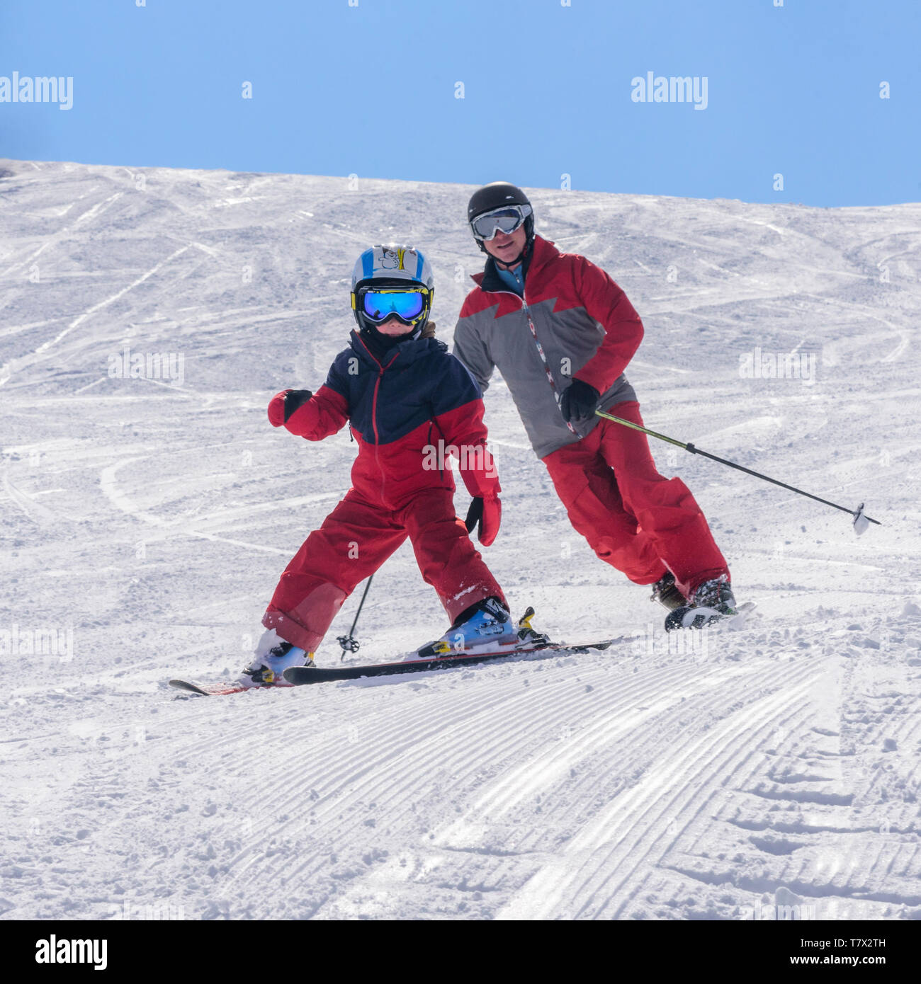 Junge Skifahren mit seinem Vater gut vorbereitet Hang Stockfoto