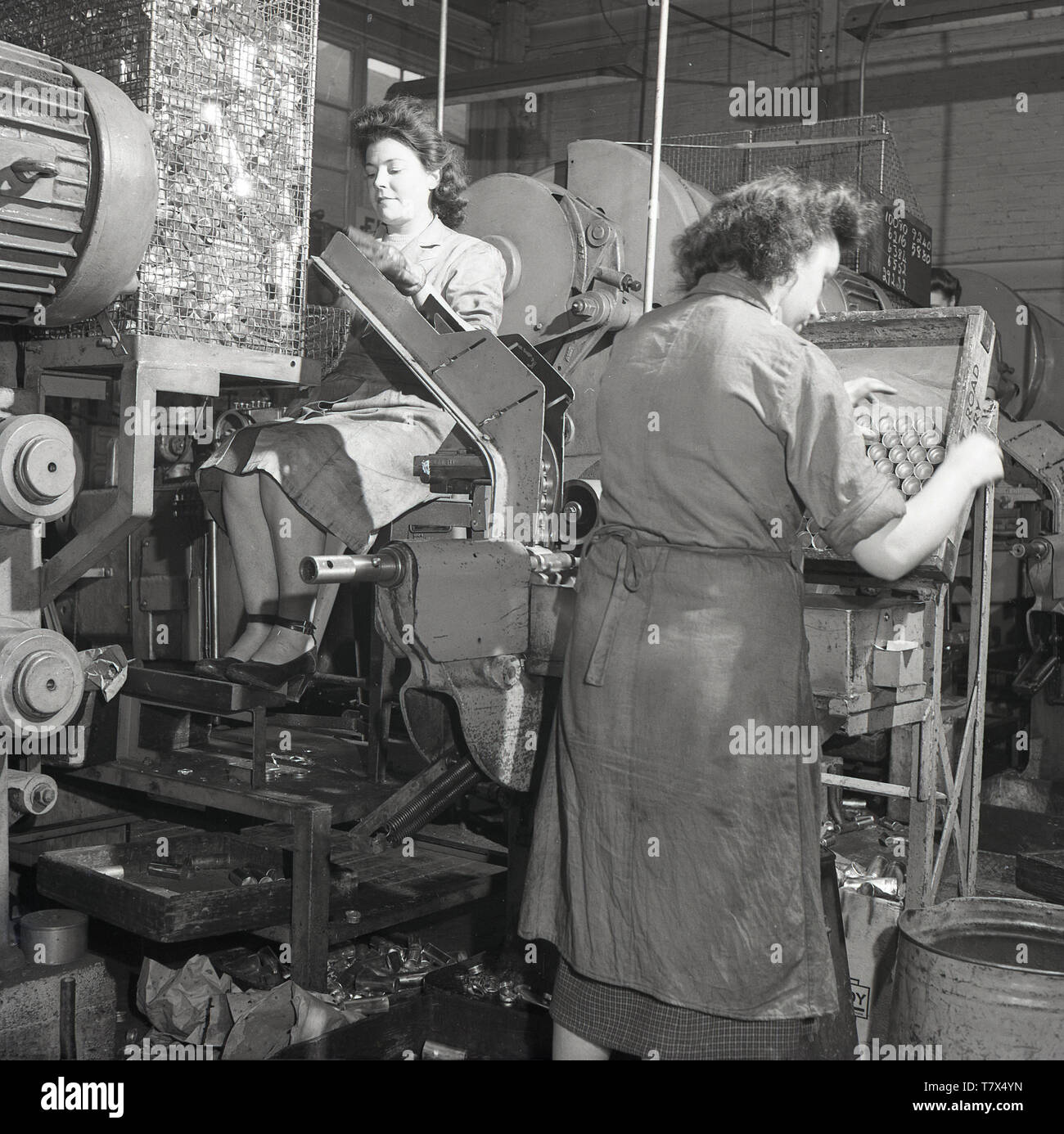 1950, historische, lady Arbeiter mit Maschinen am stets bereit, Batterie Werk in Forest Road, Walthamstow, London, England, UK. Frau eingetragen Beschäftigung in der Industrie in großen Zahlen, die während des Zweiten Weltkriegs und viele hatten nach dem Ende des Krieges. Die Foret Straße Fabrik für die Herstellung von trockenen Batterien für tragbare Radios spezialisiert. Von 1963 überhaupt bereit waren 28 Fabriken in Großbritannien beschäftigt über 12.000 Mitarbeiter. Stockfoto