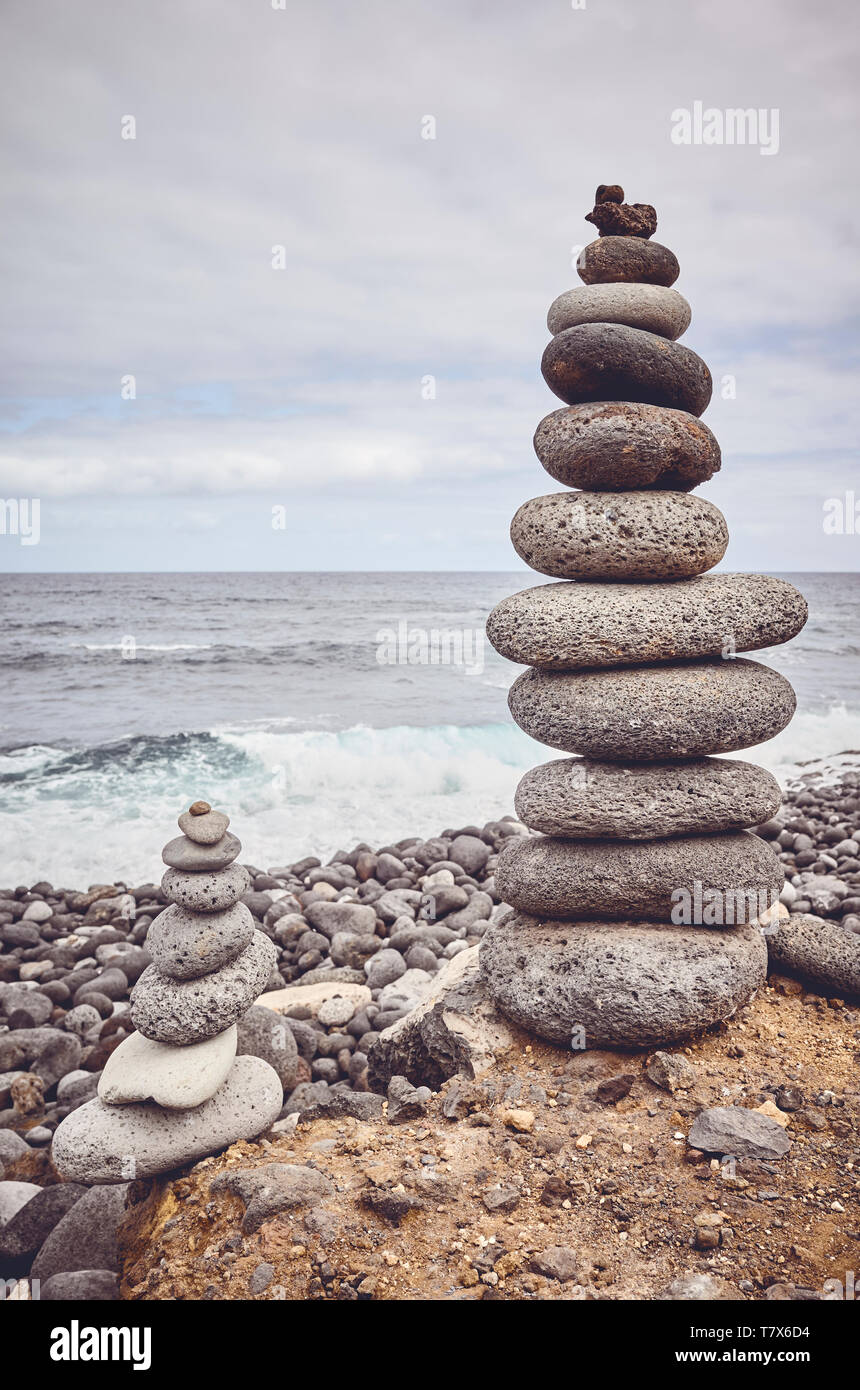 Stein thront auf einem Strand, Farbe getonte Bild. Stockfoto