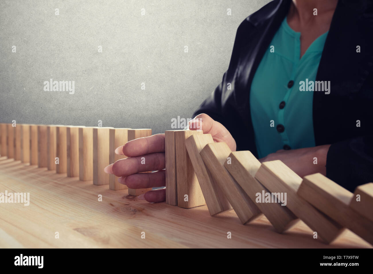 Geschäftsfrau hält eine Kette fallen wie Domino Spiel. Konzept zur Vermeidung der Krise und Ausfall im Geschäft. Stockfoto