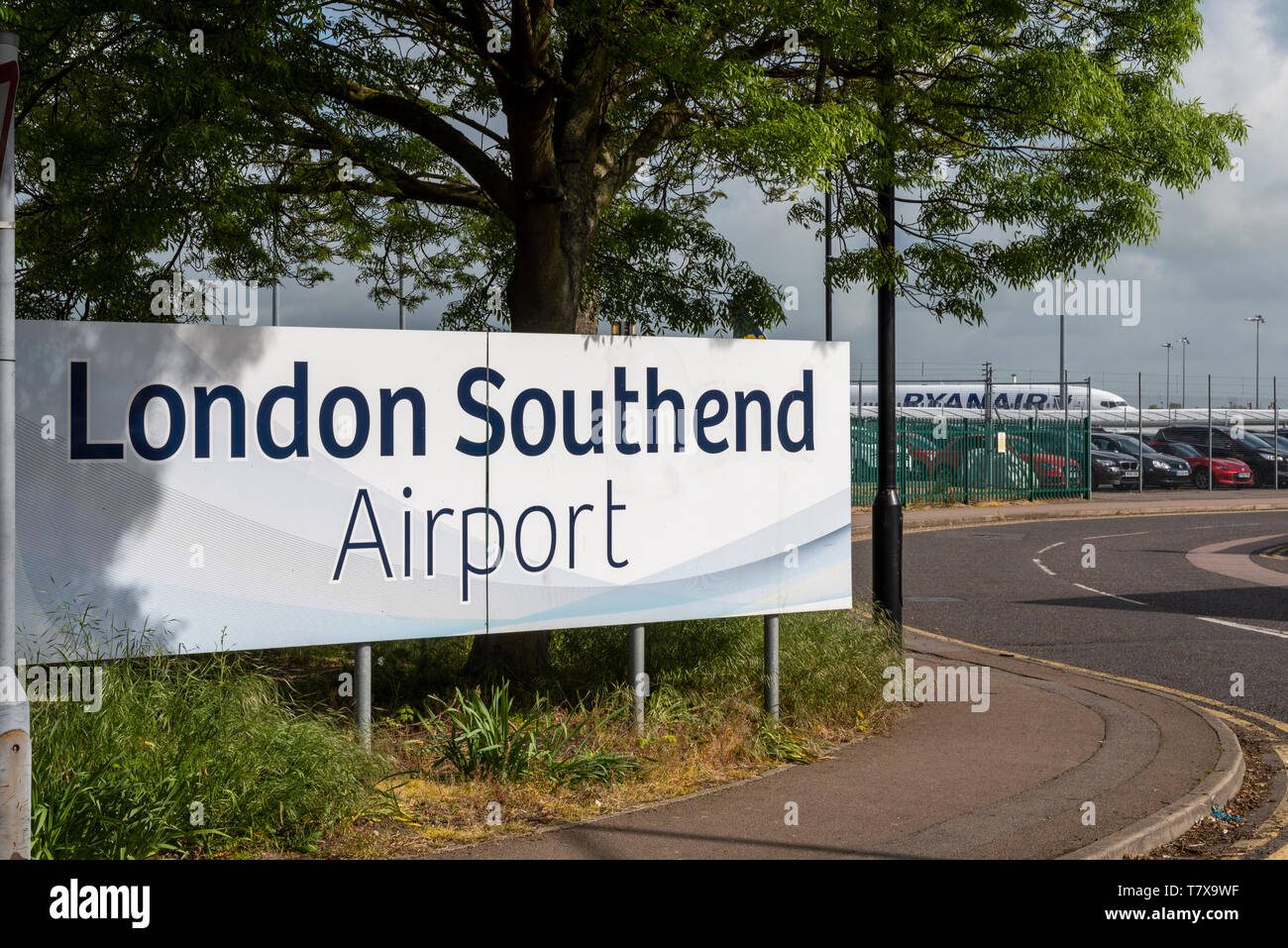Schild zum Flughafen London Southend mit dem Flugzeug von Ryanair dahinter. Southend on Sea, Essex, Großbritannien. Parkplatz. Autos. Parken Stockfoto