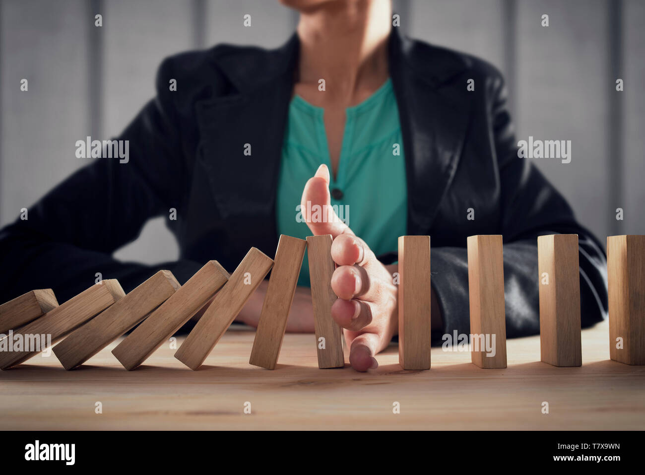 Geschäftsfrau hält eine Kette fallen wie Domino Spiel. Konzept zur Vermeidung der Krise und Ausfall im Geschäft. Stockfoto