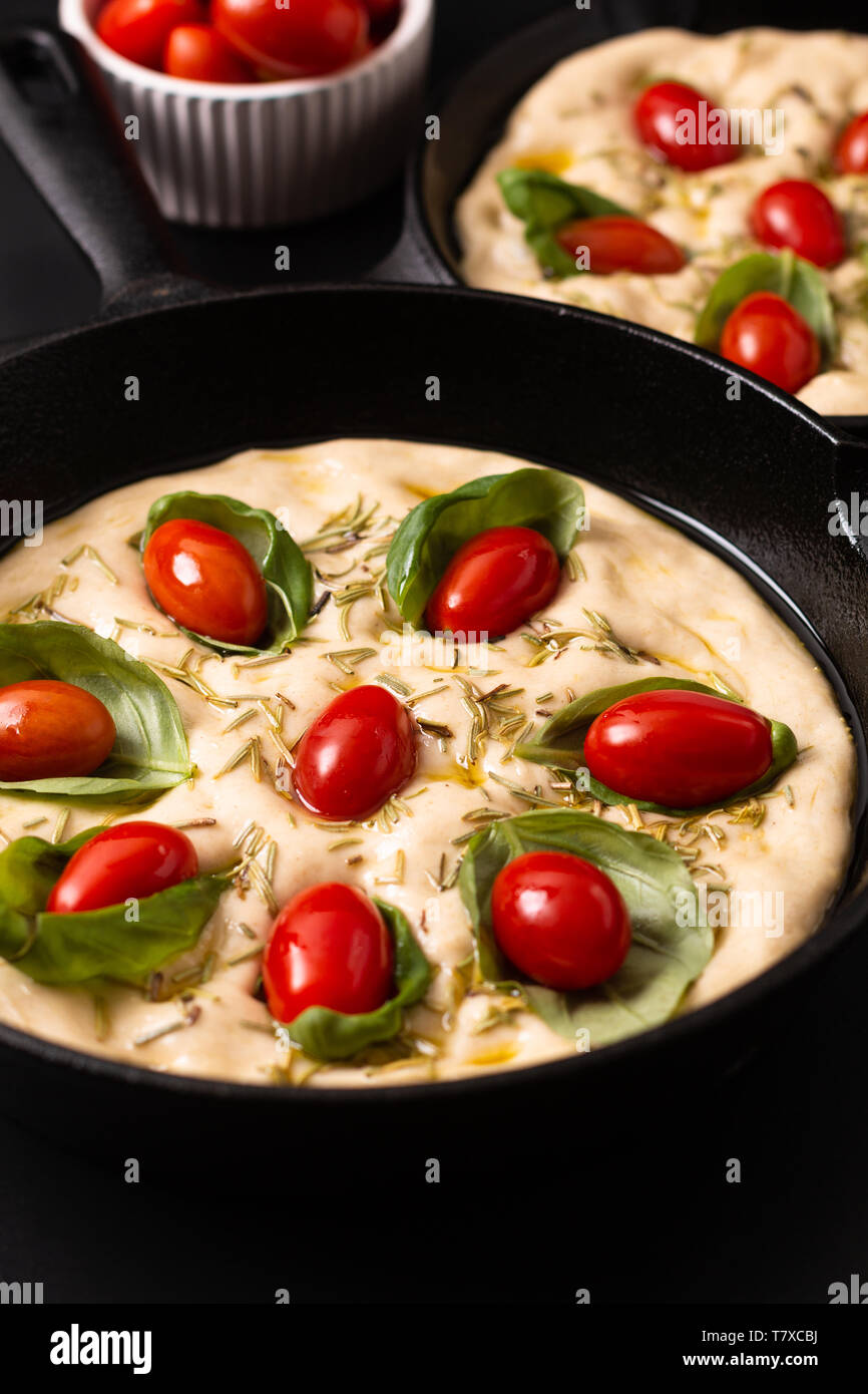 Essen Konzept steigende Teig für vegane Hausgemachte organische Focaccia in Skillet eiserne Pfanne auf schwarzen Hintergrund mit Kopie Raum Stockfoto