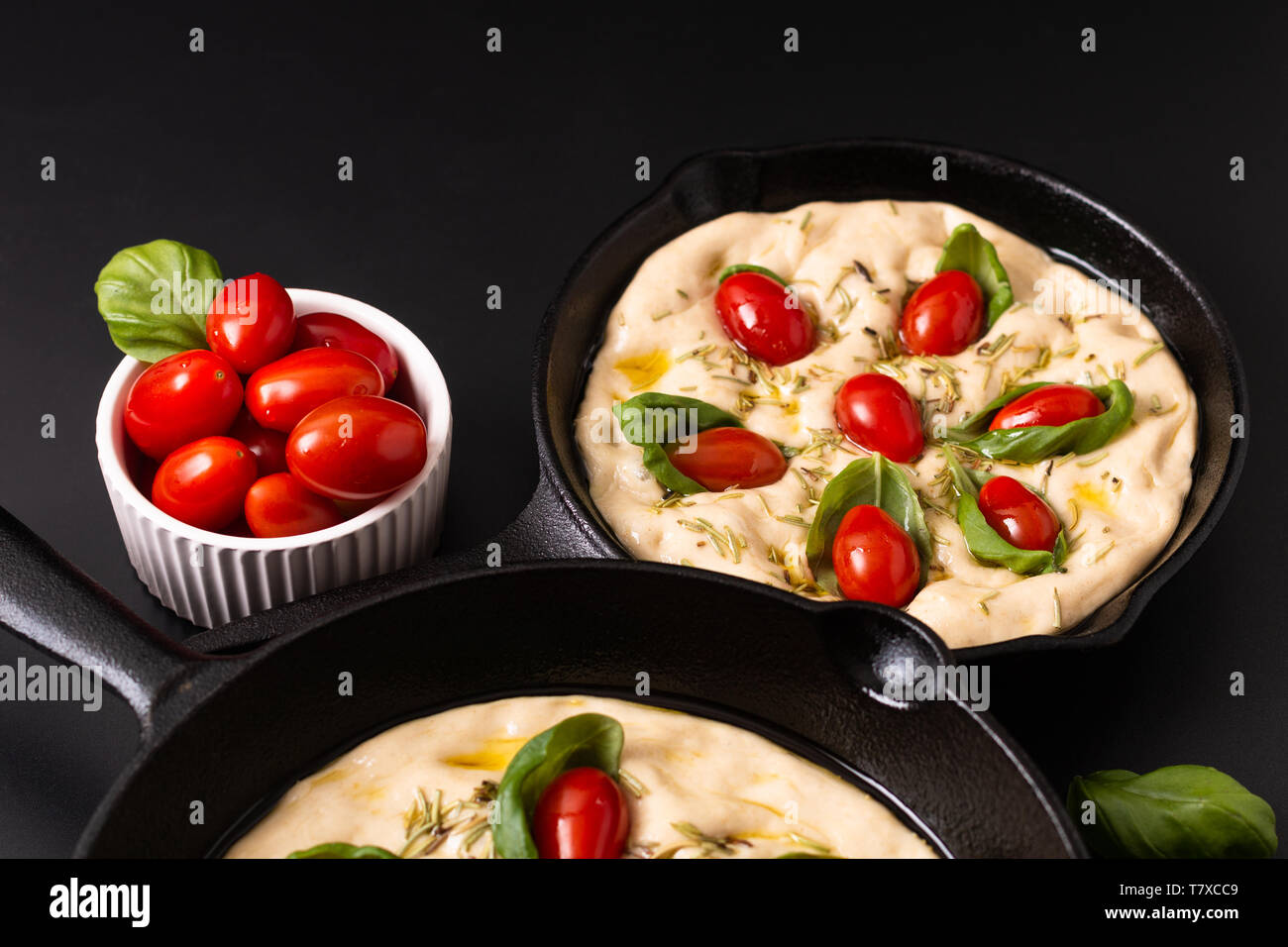 Essen Konzept steigende Teig für vegane Hausgemachte organische Focaccia in Skillet eiserne Pfanne auf schwarzen Hintergrund mit Kopie Raum Stockfoto