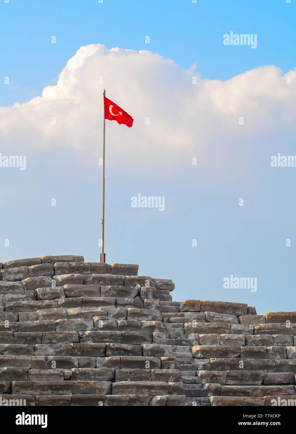 Türkische Flagge auf einem antiken Amphitheater vor dem Hintergrund einer großen Wolke close-up Stockfoto