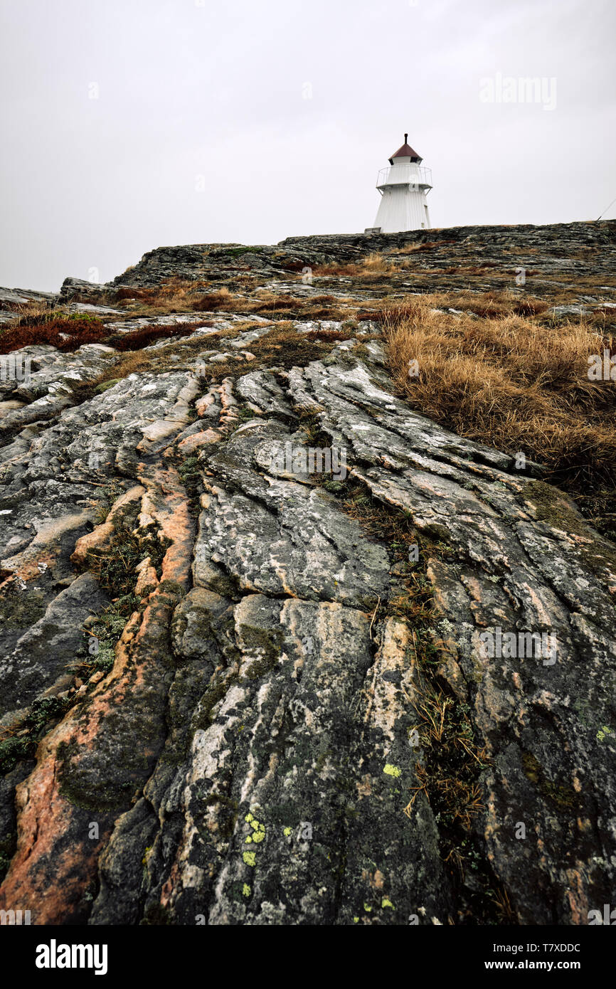 Eine einsame Kleine automatische Leuchtturm und gestreift Gneis rock Geologie im Westen Schwedens Küste. Stockfoto