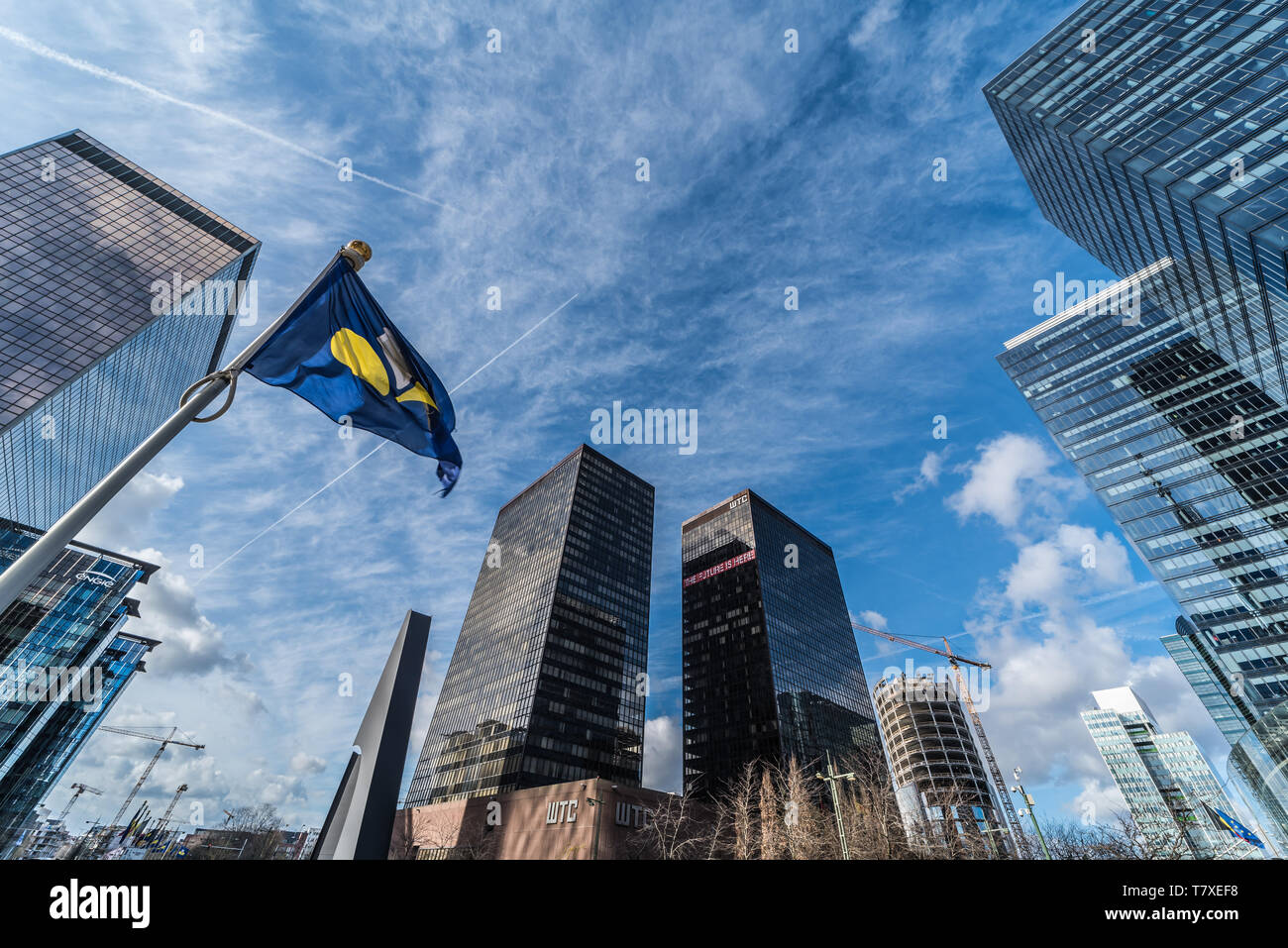 Brüssel, Belgien - 03 10 2019: moderne Wolkenkratzer aus Glas und Stahl der Kleinen Manhattan Business Bezirk mit einem Brüssel Iris Flagge Stockfoto