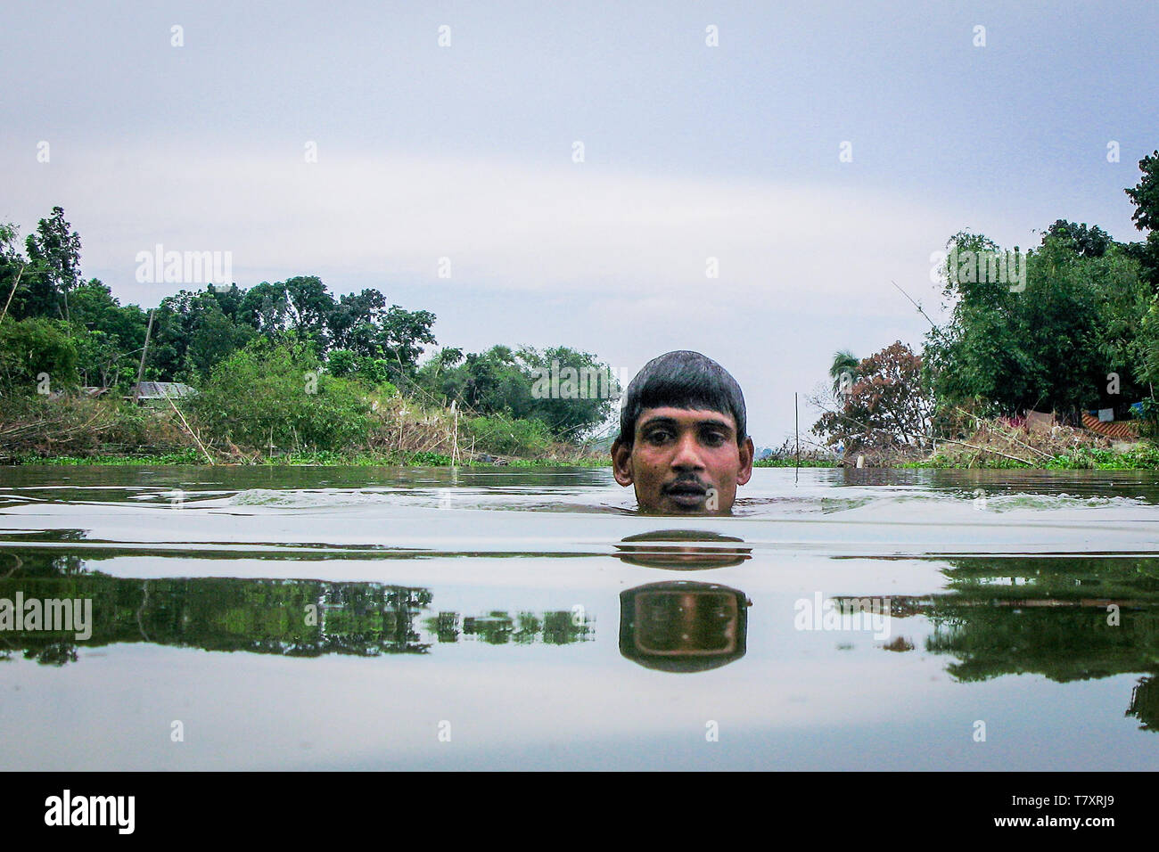 Mohammad Khokon schwimmt auf dem Jamuna Flusses, wo sein Haus verwendet werden. Eine grelle Flut gewaschen in den Yamuna Fluss in Sirajganj, Bangladesch im Jahr 2007. Die globale Erwärmung verursachen der Monsun Regen und Überschwemmungen früher zu starten. Die globale Erwärmung auch accellerate das Schmelzen von Eis und Schnee im Himalaya, die Feeds in den bereits gesättigten Flüsse, der Ganges Delta machen. Das Resultat ist verheerend für Menschen, die in den dicht besiedelten delta Bereich leben. Während der Himalaya und Überschwemmungen aus dem Norden wreak Verwüstung, der Anstieg des Meeresspiegels Salzwasser eindringen in die geringe Ursache liegenden landwirtschaftlichen Zonen alo Stockfoto