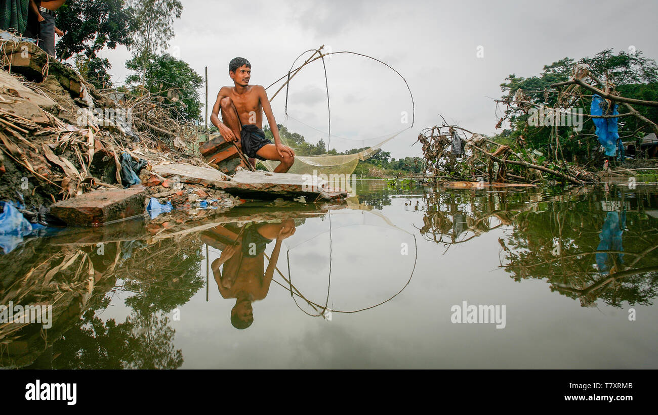 Mohammad Khokon sitzt neben Was verwendet das Haus seiner Familie zu sein. Eine grelle Flut gewaschen in den Yamuna Fluss in Sirajganj, Bangladesch im Jahr 2007. Die globale Erwärmung verursachen der Monsun Regen und Überschwemmungen früher zu starten. Die globale Erwärmung auch accellerate das Schmelzen von Eis und Schnee im Himalaya, die Feeds in den bereits gesättigten Flüsse, der Ganges Delta machen. Das Resultat ist verheerend für Menschen, die in den dicht besiedelten delta Bereich leben. Während der Himalaya und Überschwemmungen aus dem Norden wreak Verwüstung, der Anstieg des Meeresspiegels Salzwasser eindringen in die geringe Ursache liegenden landwirtschaftlichen Zonen entlang. Stockfoto