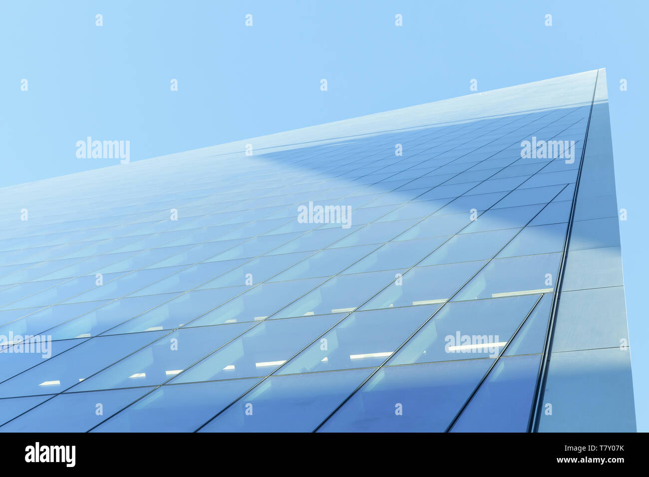 Abstrakte moderne Architektur Fragment, Ecke von Wänden aus glänzendem Glas und Stahl unter blauem Himmel Stockfoto