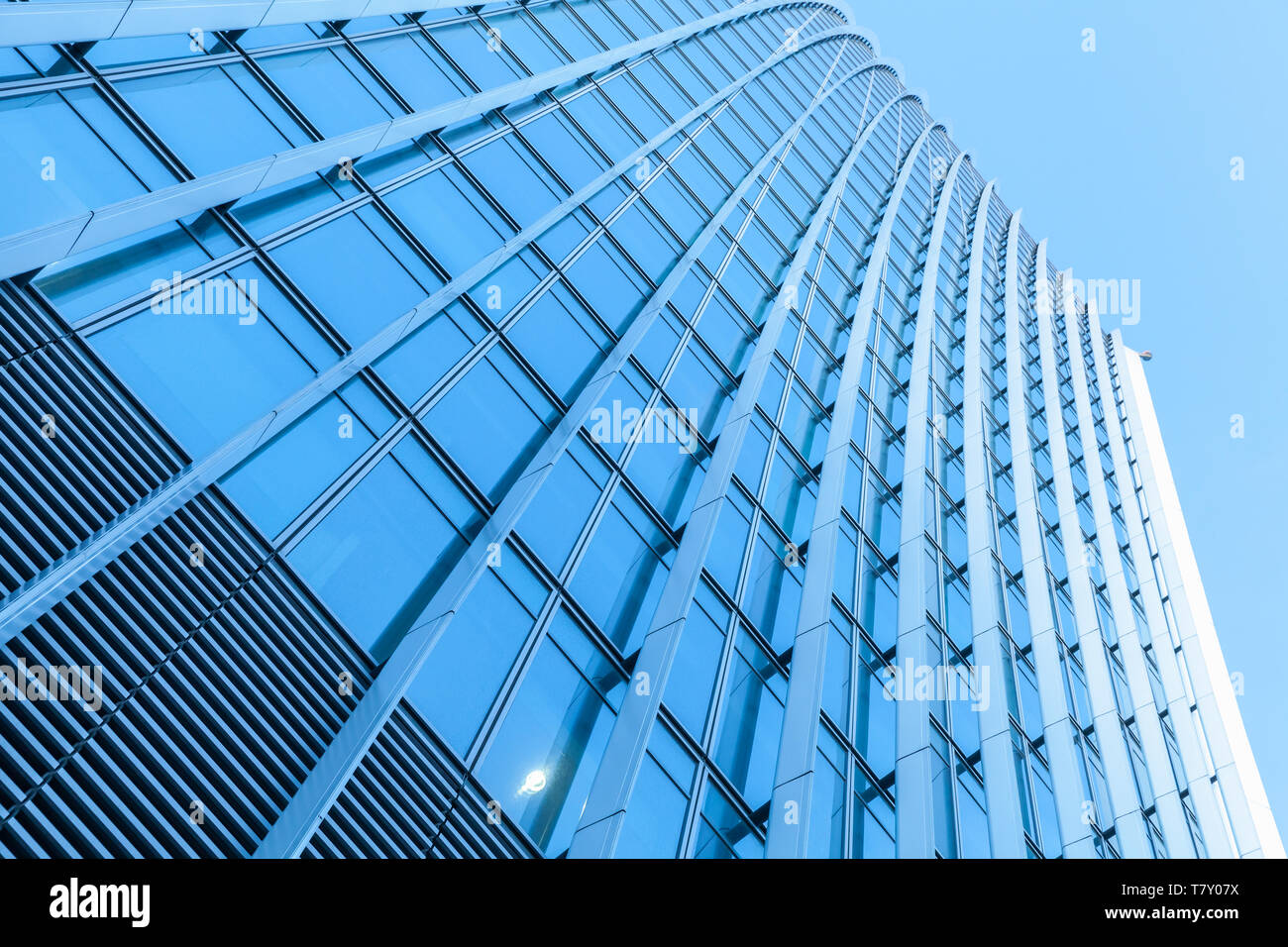 Abstrakte moderne Architektur Fragment, Bürogebäude Wand aus Metall und glänzend Glas unter blauen Himmel Stockfoto